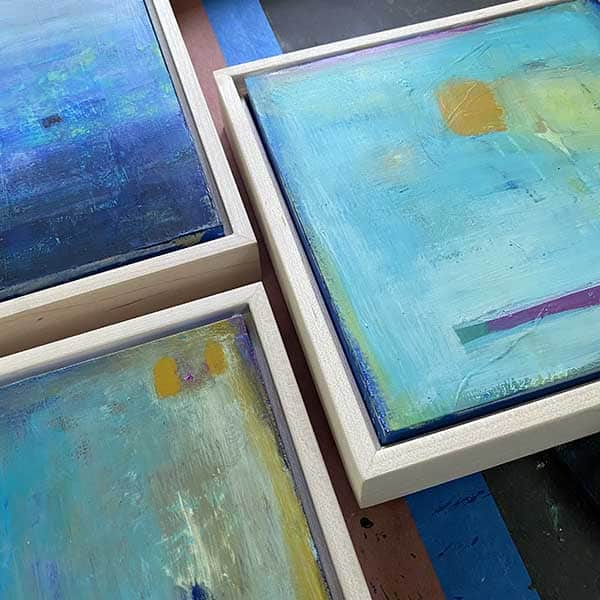 partial view of three small framed paintings